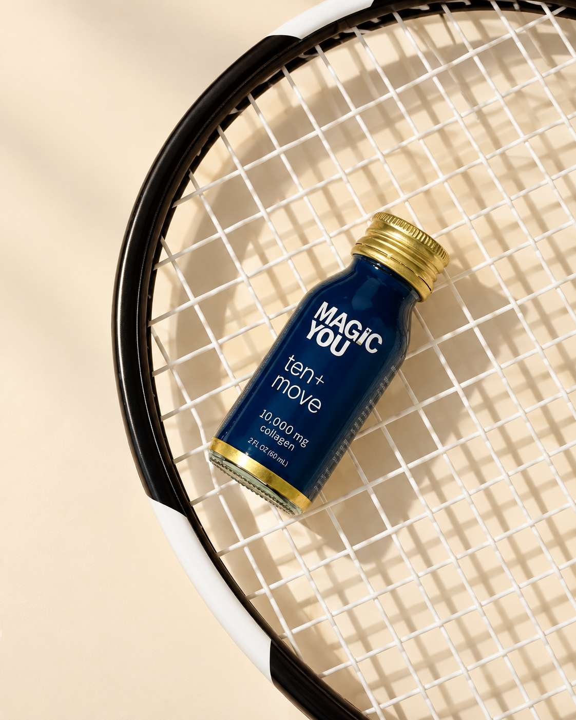 Magic You ten+move bottle on a tennis racket in warm natural light