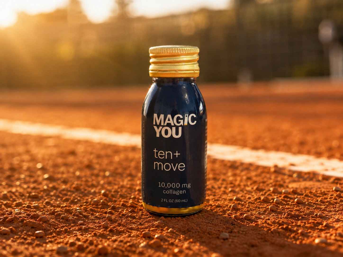 Magic You ten+move bottle on a sunlit clay tennis court